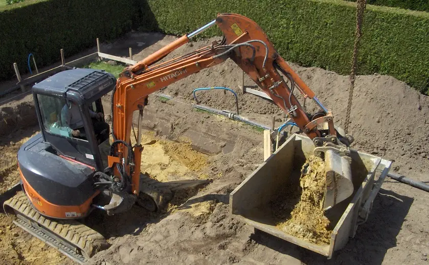 Graafkraan laadt grond in een container