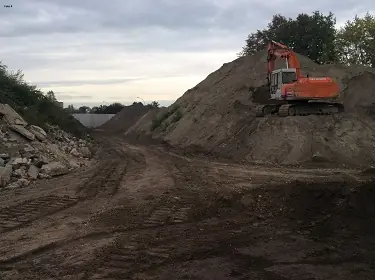 Graafkraan op een grondberg in het depot