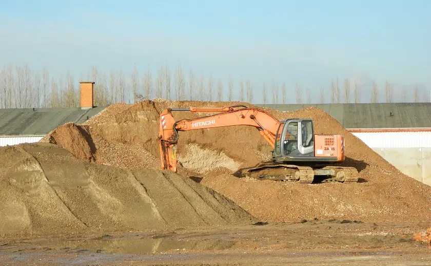 Grondstock en graafkraan in het recyclagecentrum