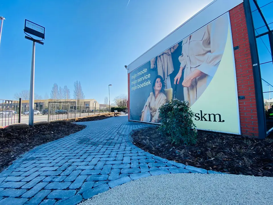 Verharding in kasseien langs de gevel van SKM in Aartselaar