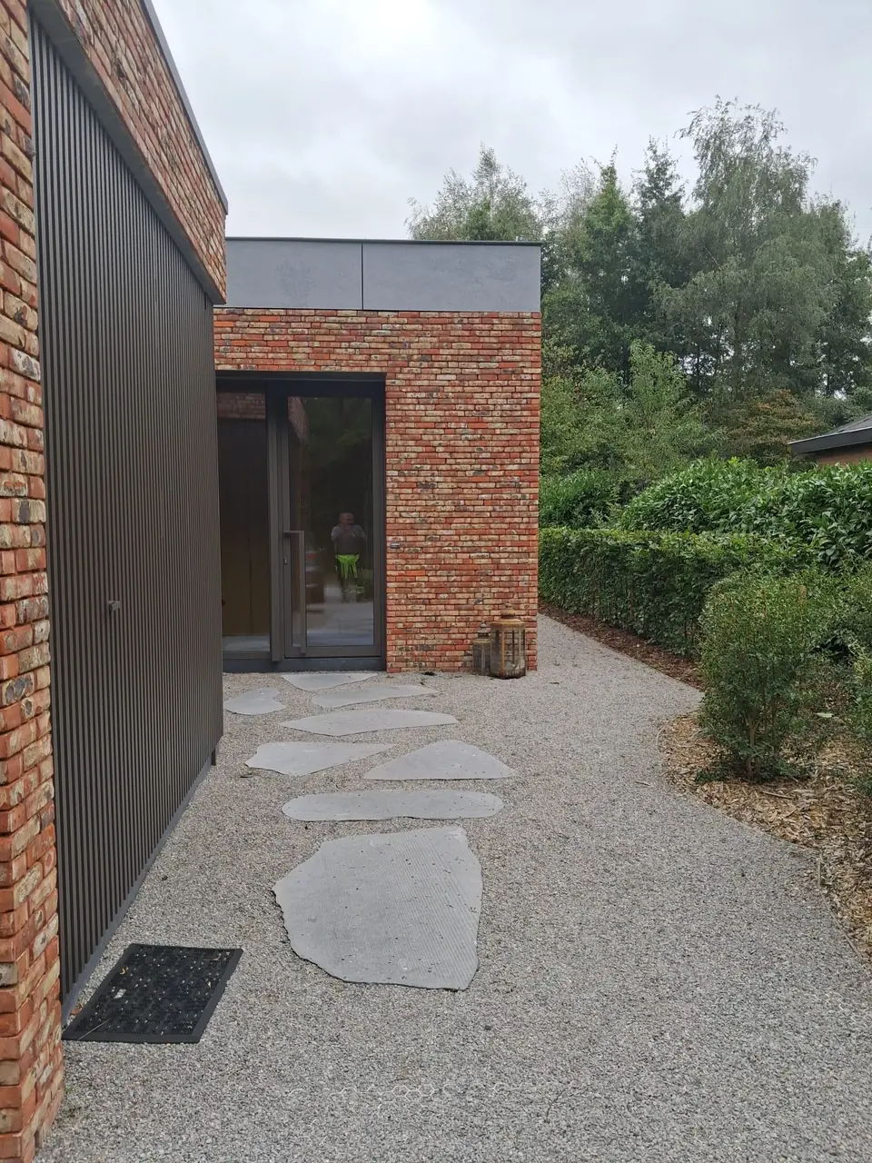 Pad in natuursteen en grind langs de gevel