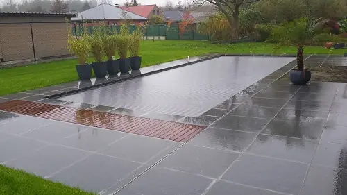 Afgedekt zwembad met terras in natuursteen