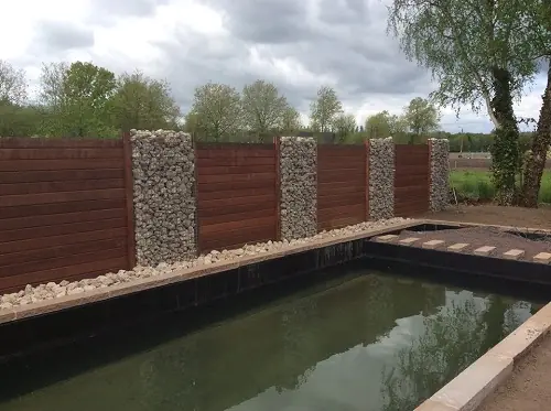 Zwemvijver met houten wand en schanskorven in Heffen